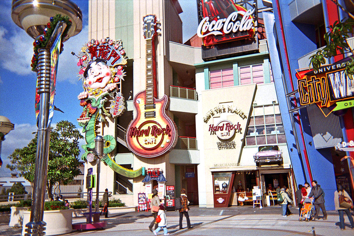 The Hard Rock Cafe Osaka Universal Studios featuring a giant neon guitar and a massive neon Japanese kite out front.