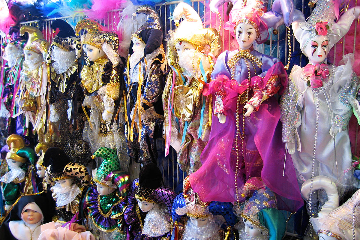 Colorful New Orleans dolls and puppets with mime faces and shiny fabric clothes.