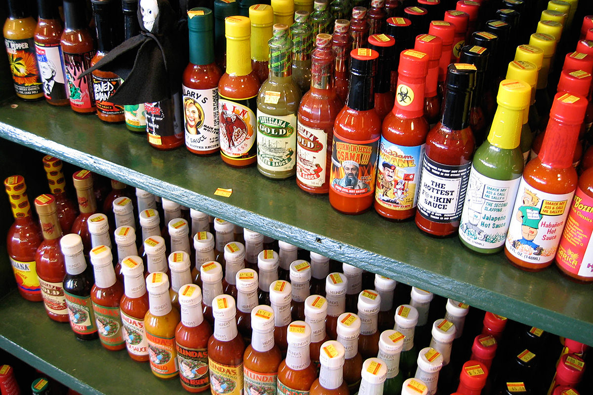 Shelves filled with many, many different hot sauces.