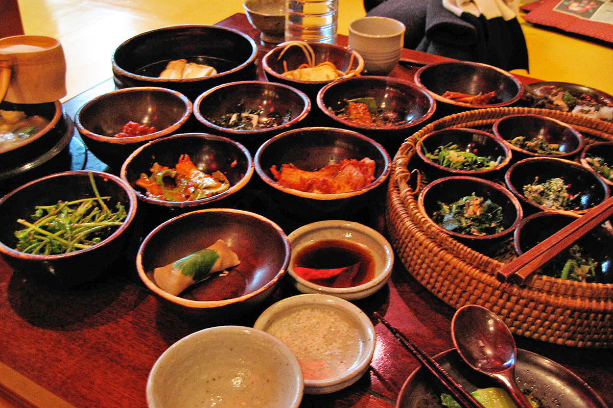 A low table filled with all kinds of small dishes filled with various Korean foods.