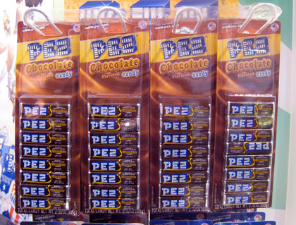 Bags of Chocolate PEZ candies hanging on a rack.