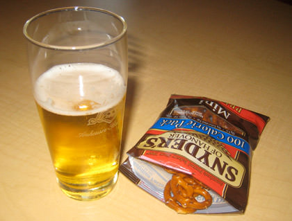 A glass of Budweiser and a bag of pretzels