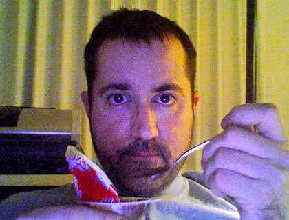 Dave eating pudding with a new haircut.