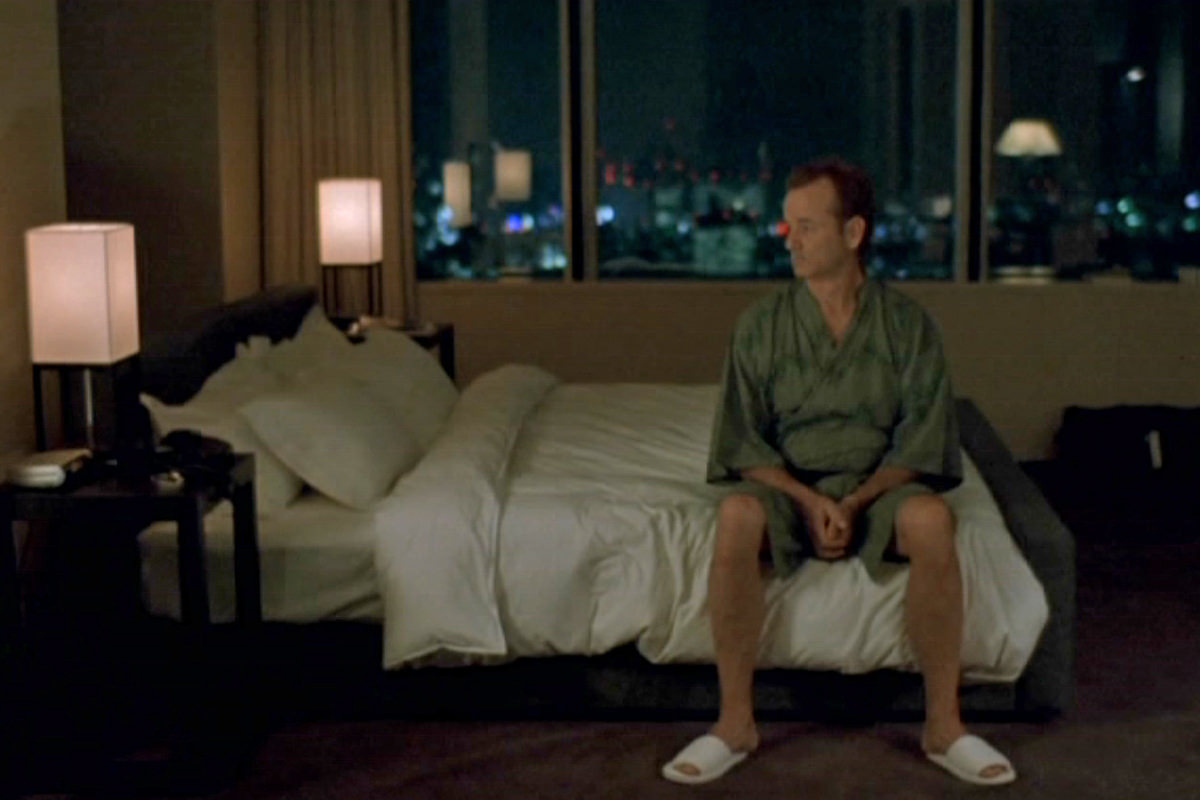 Bill Murray in a scene from Lost in Translation where he's sitting on a hotel bed feeling lost.