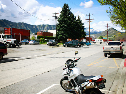 A photo of my motorcycle parked in front of my office with a train rumbling through town in the background.