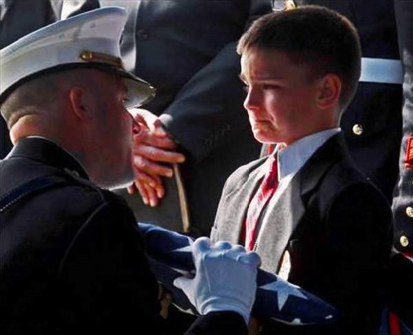 Young boy receives a flag from his father's funeral.