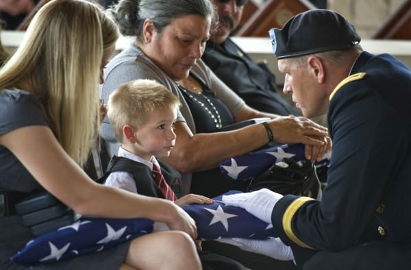 Young boy receives a flag from his father's funeral.