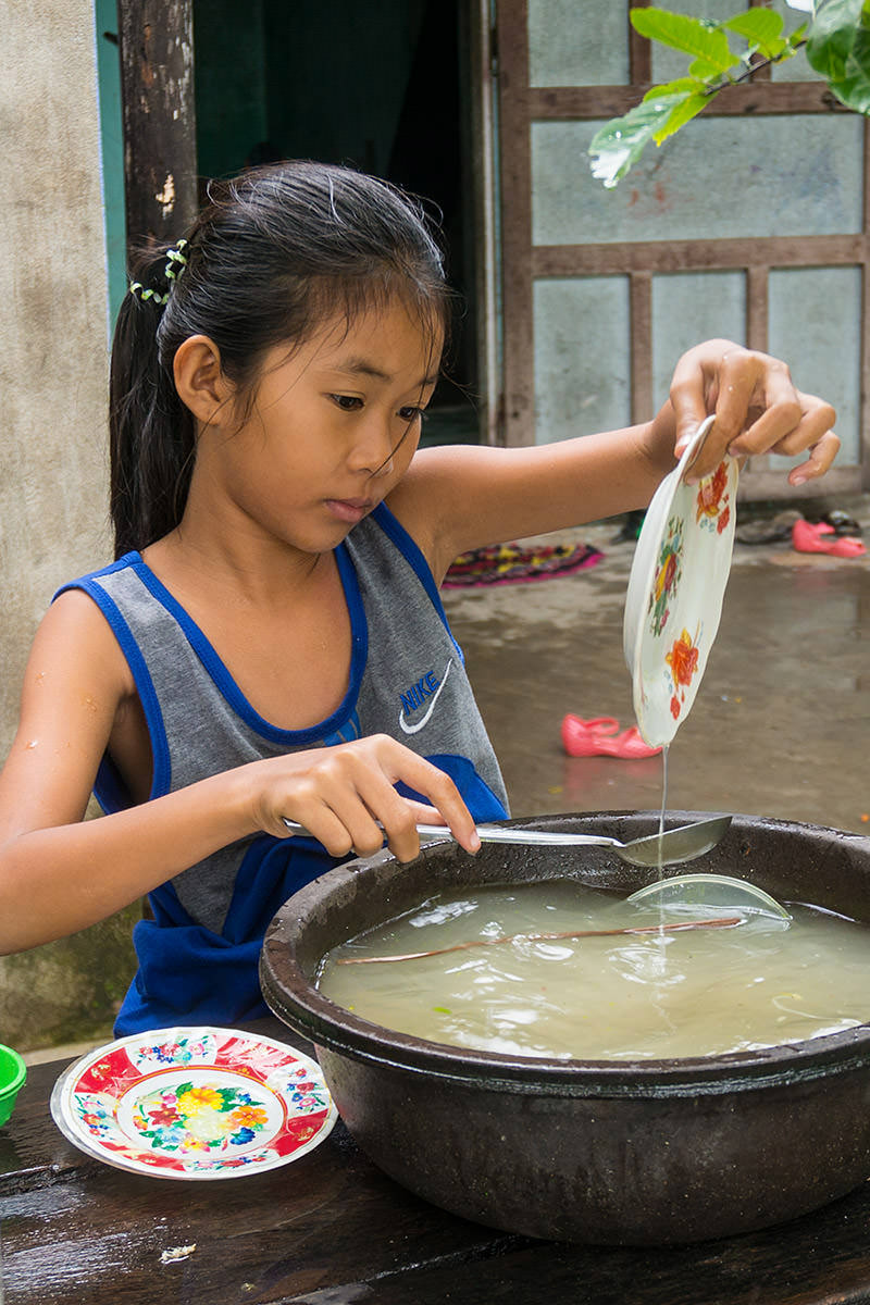 Girl Washing Dishes in Hoi An, Vietnam
