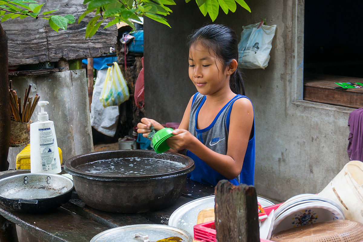 Girl Washing Dishes in Hoi An, Vietnam