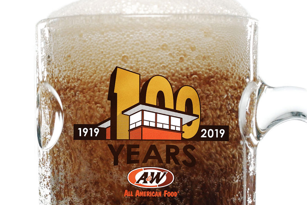 A mug of frosty A&W root beer with a 1919-2019 logo on it, showing a giant '100' that's cut into an outline of an A&W drive-in.