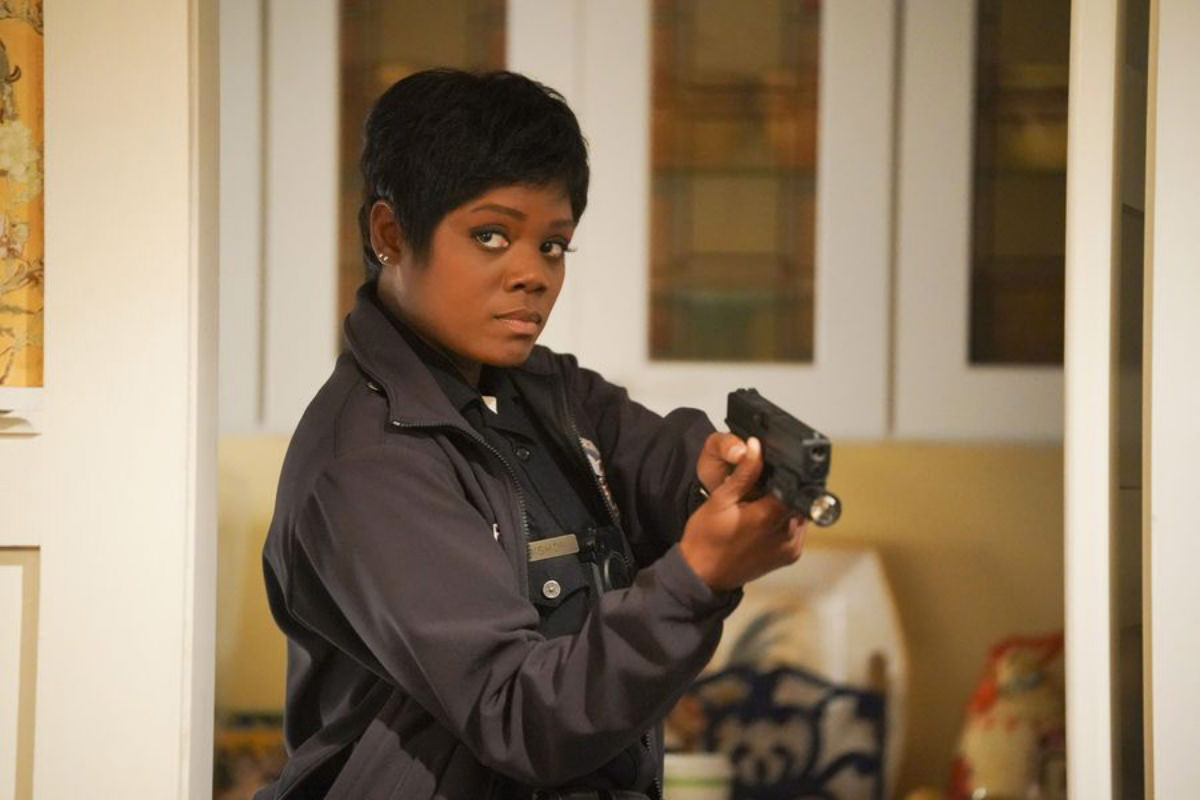 Afton Williamson as police officer Talia Bishop on The Rookie holding a gun and about to kick ass.