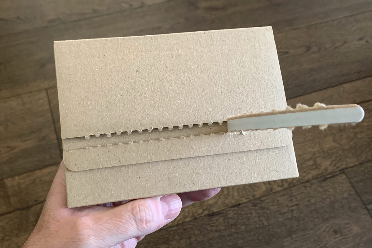 A plain brown kraft envelope being opened.