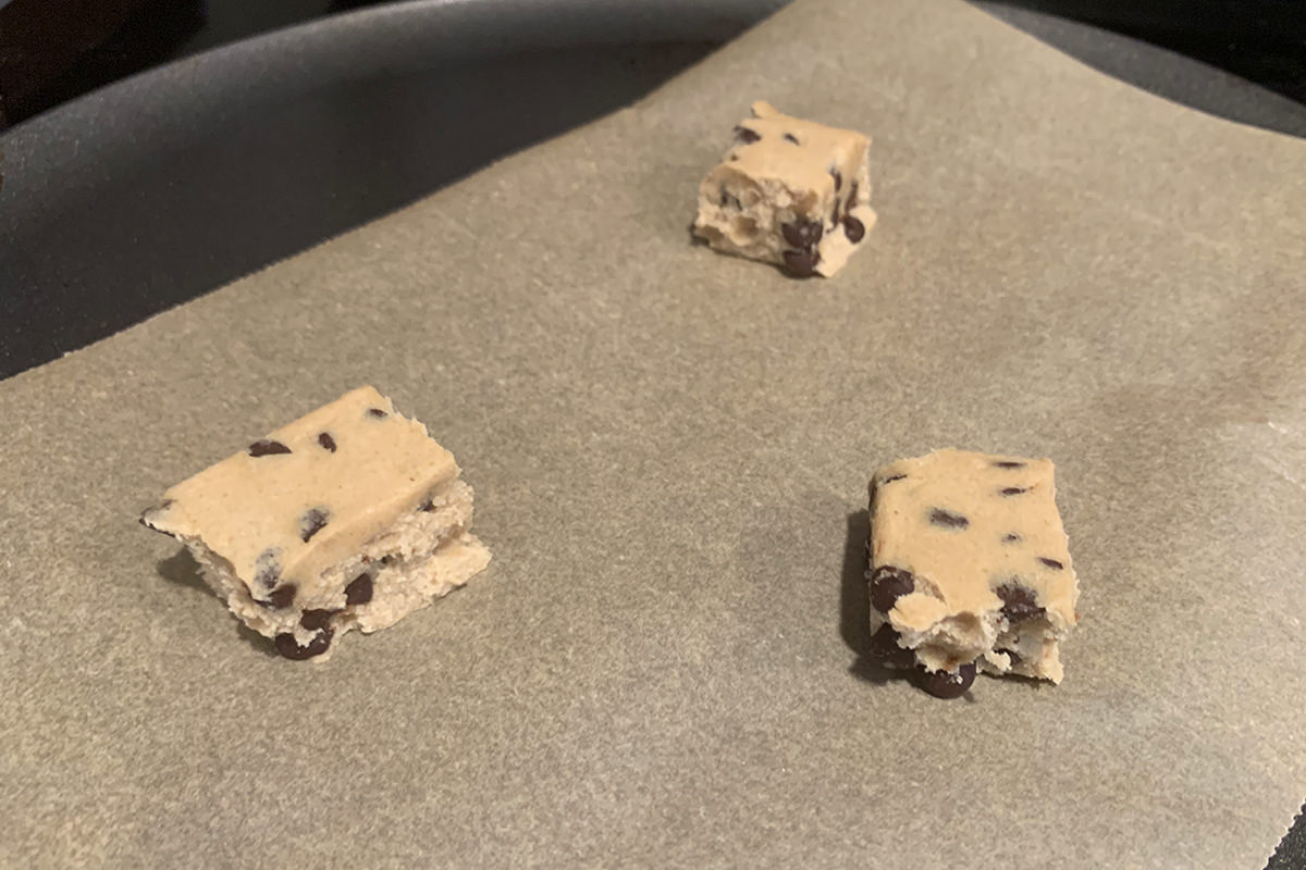 Raw cookie dough cube that have been broken off.