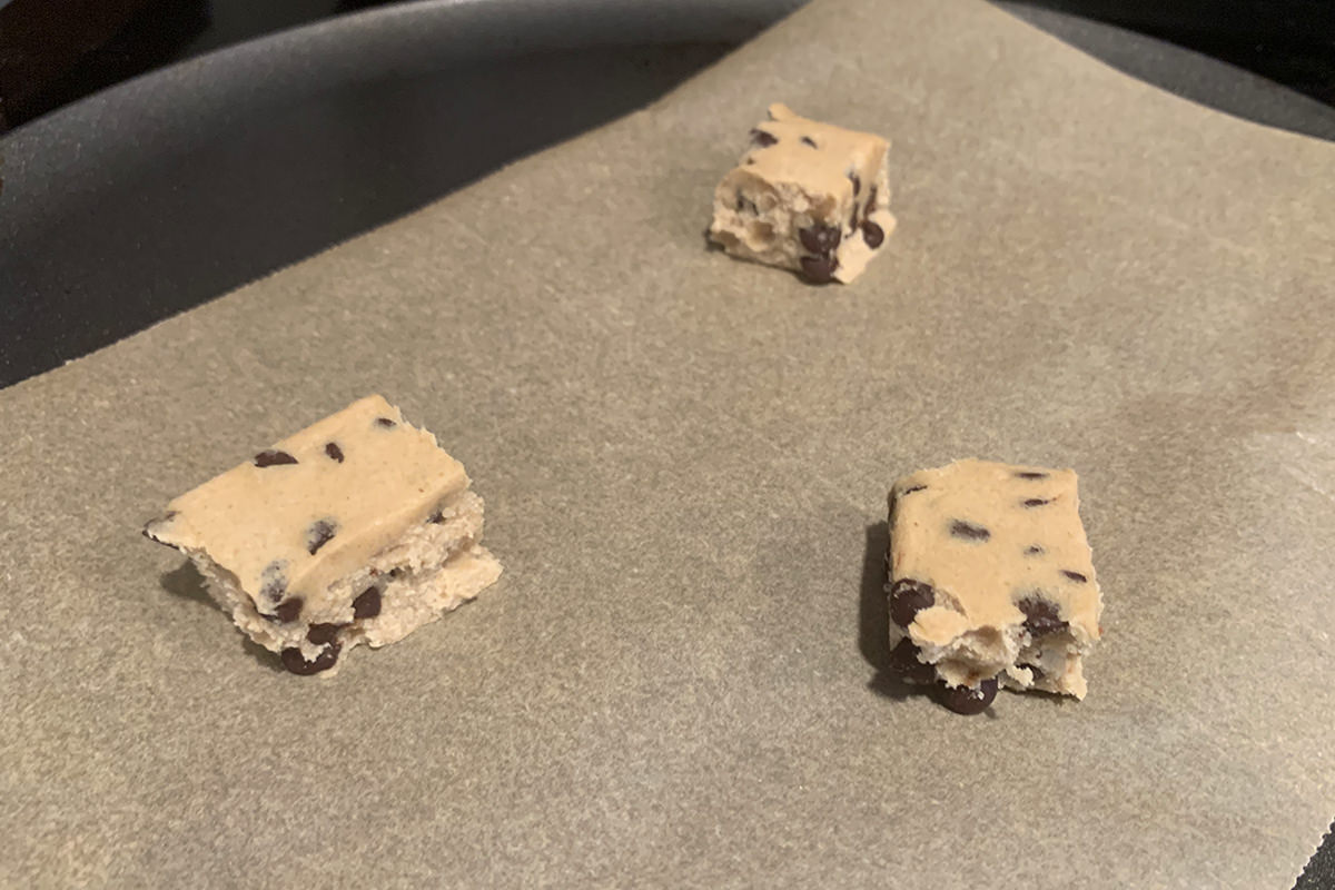 Raw cookie dough cube that have been broken off.