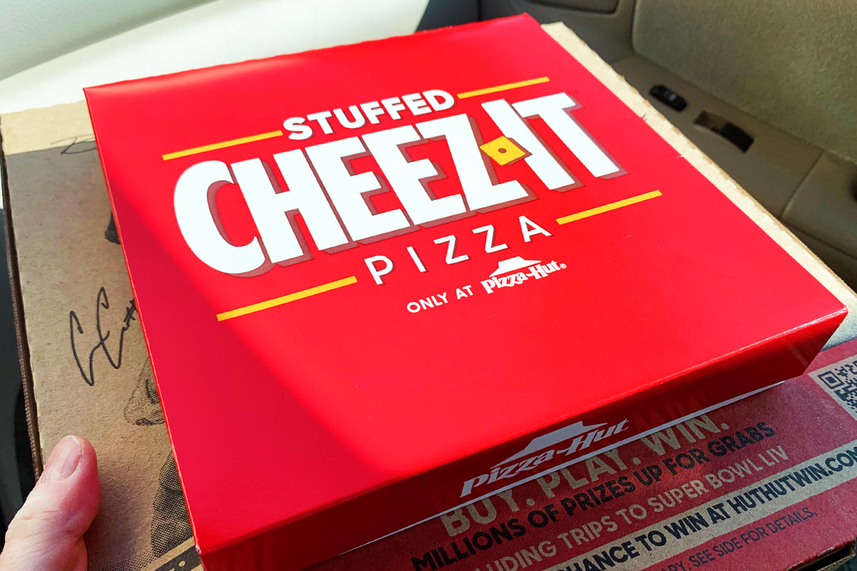 A stunningly red Cheez-It Pizza box, glinting in the sunlight of my car passenger seat.