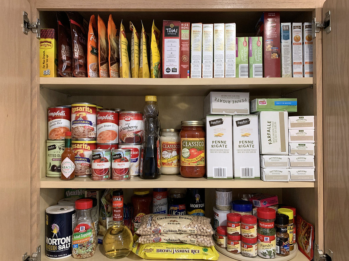 A photo of my cupboard with boxes, cans, and pouches all neatly arranged and organized so I can find things easily.