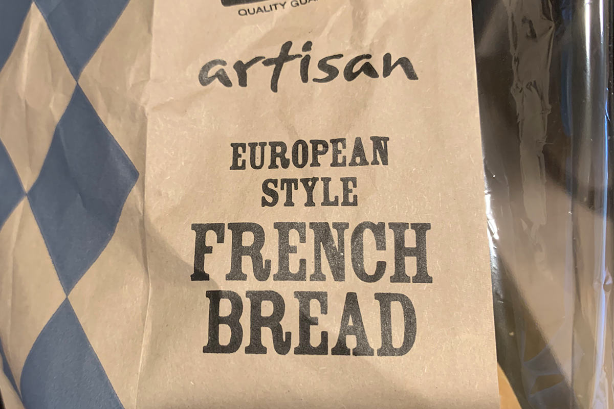 A brown bag wrapped which says Artisan European Style French Bread on it.