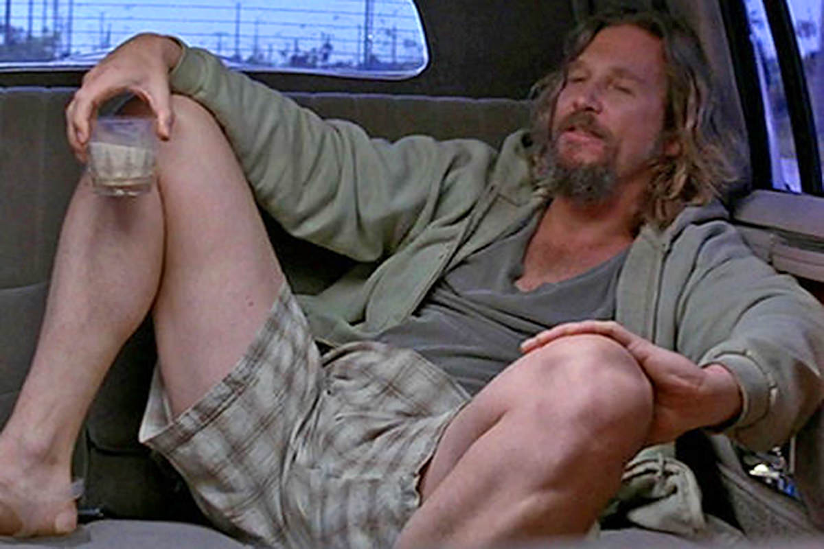 Jeff Bridges as The Dude from The Big Lebowski, sitting spread eagle in a limo while drinking a white Russian.