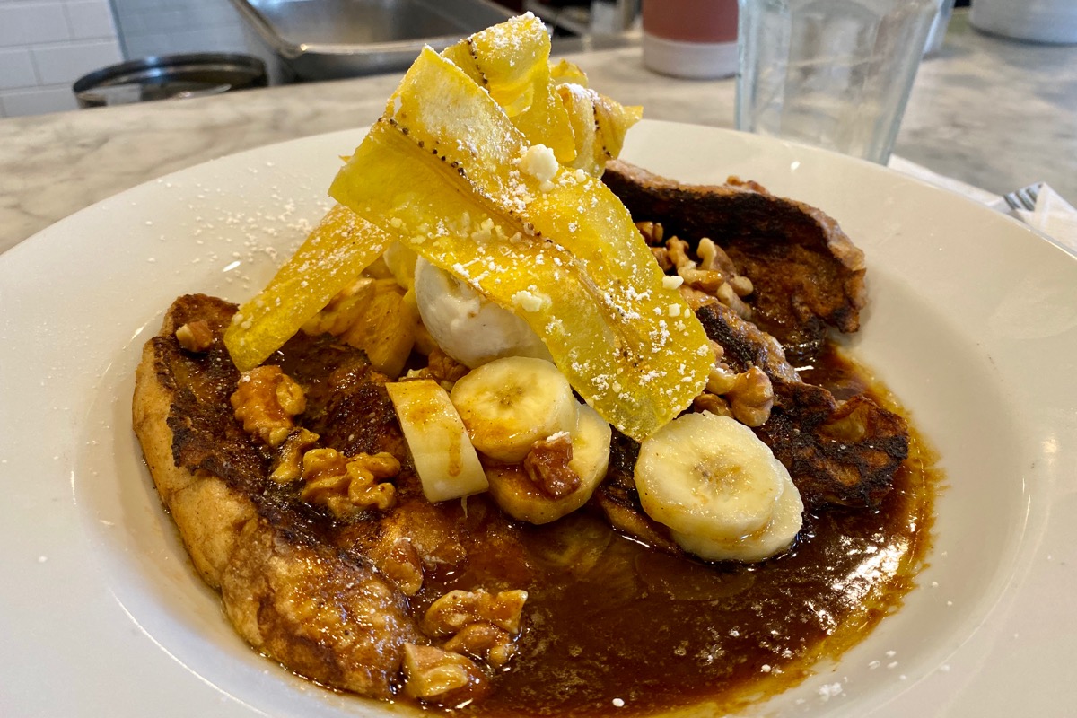 Bananas Foster French Toast with a scoop of ice cream and some banana chips on top.