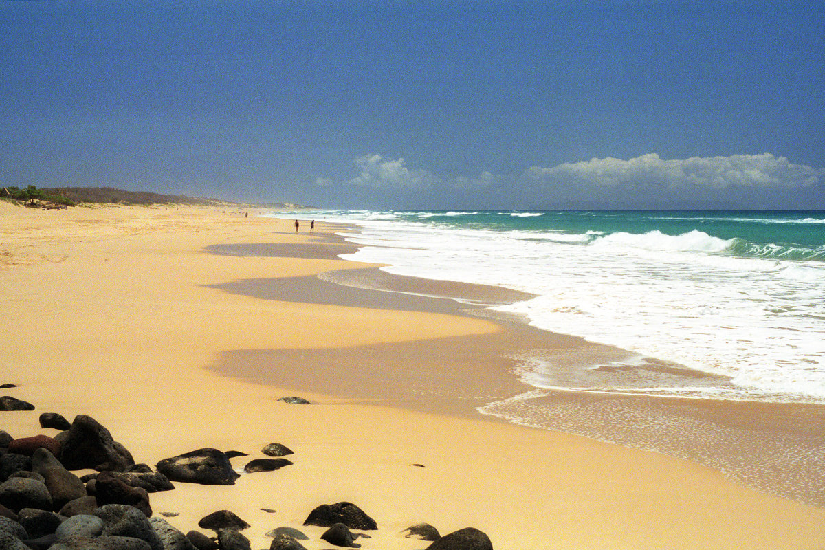 A photo of gorgeous Polihale Beach with some people far off in the distance.