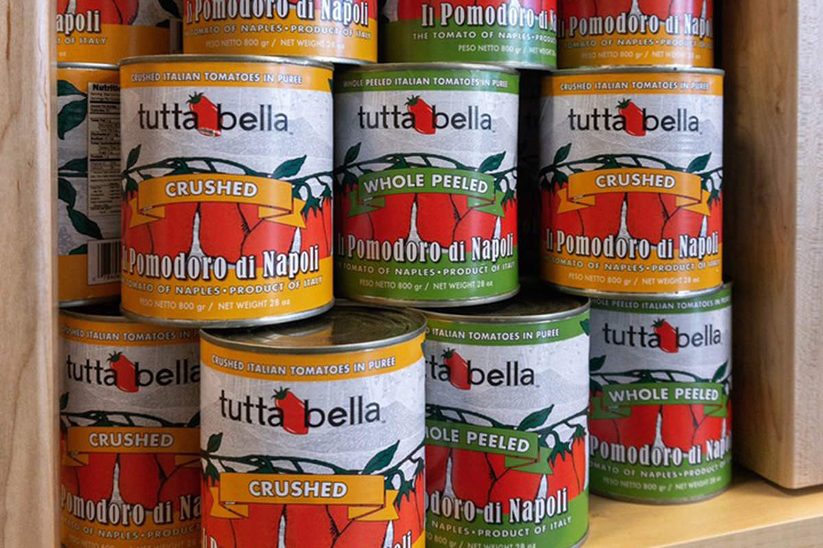 Cans of Tutta Bella tomatoes in somebody's cupboard.