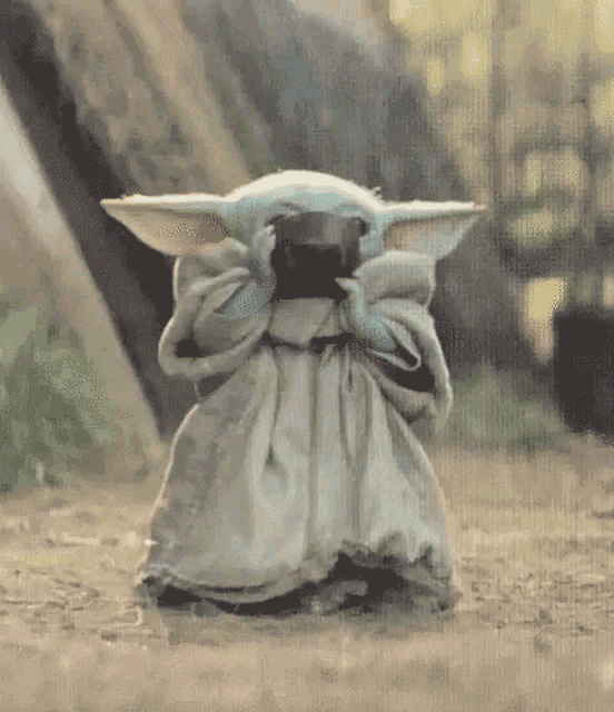 Baby Yoda, the cutest thing in the universe, is drinking tea adorably then blinking even more adorably.