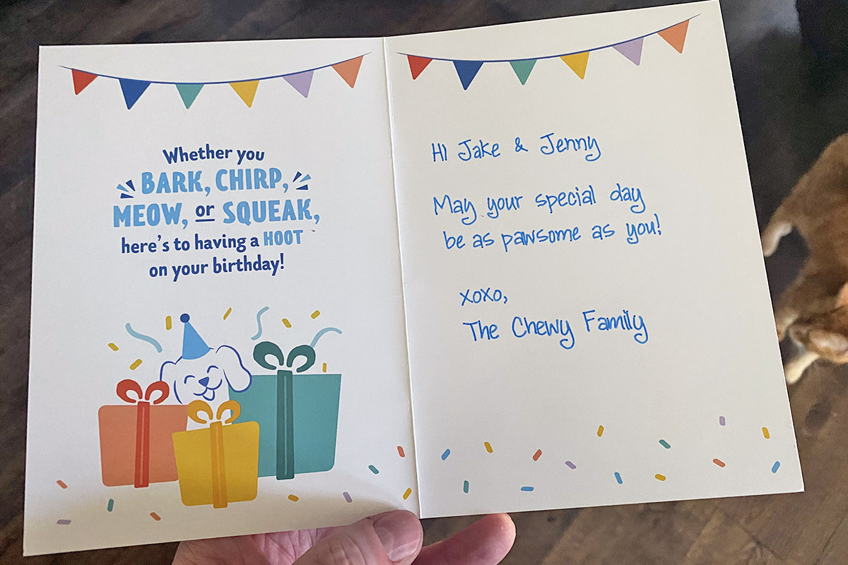 A birthday card from Chewy which says Whether you bark, shirp, meow, or squeak, here's to having a hoot on your birthday. It's hand-signed Hi Jake and Jenny, May your special day be as pawsome as you! XOXO The Chewy Family.