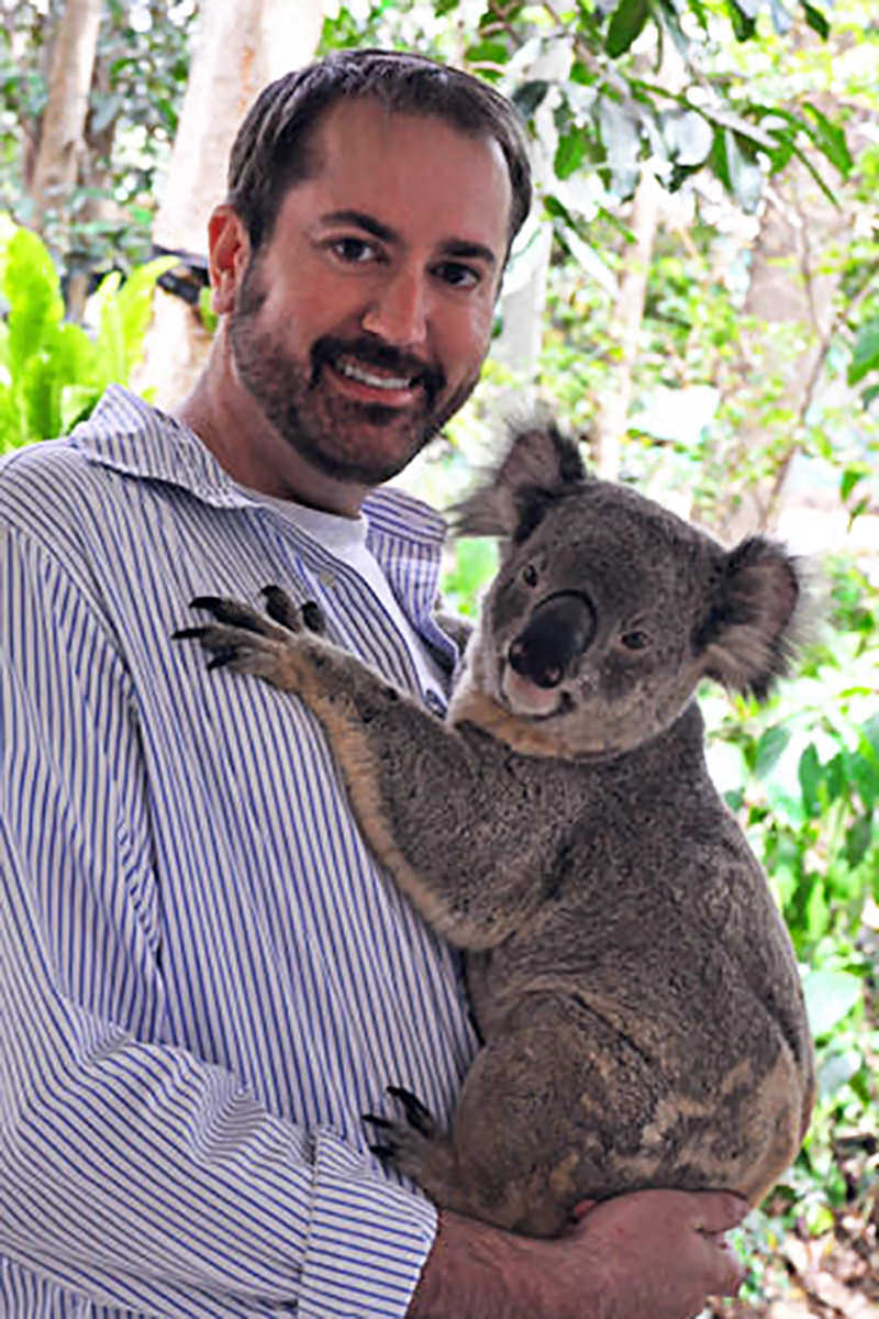 Me holding a koala... both of us looking into the camera while I'm having the time of my life.
