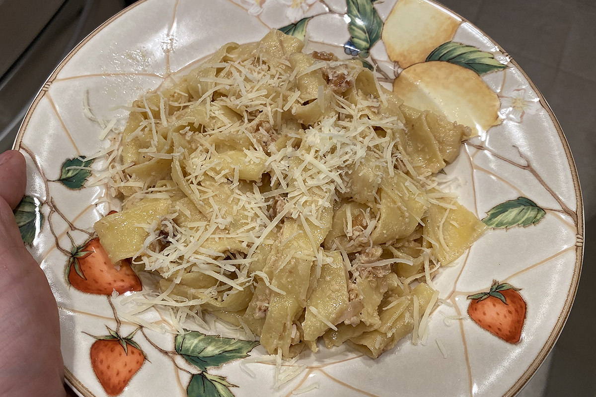 My dinner. It's a plate of thick pasta in a cream sauce with walnuts and onions.