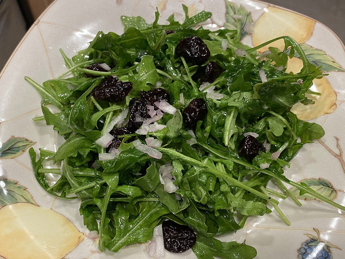 My dinner, Part 2. It's a bowl of greasy arugula with dried cherries on top.