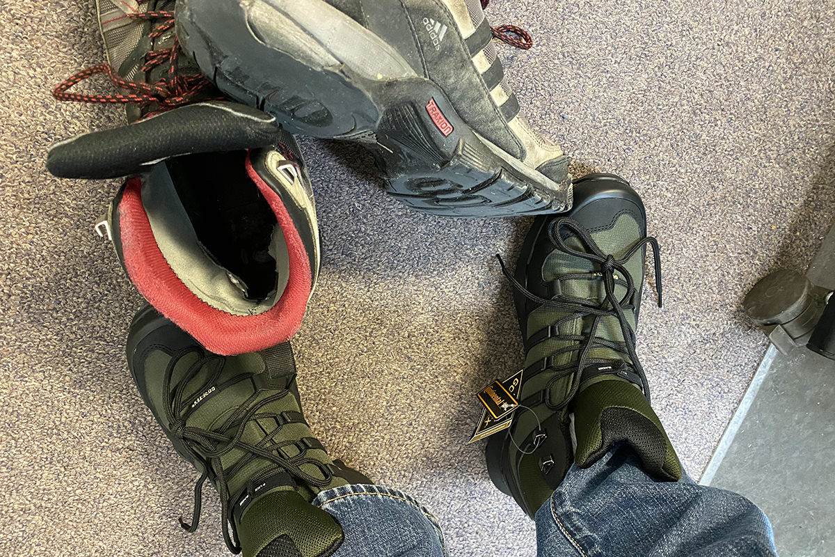 A photo of my new boots that look rugged in their forest green and balck... plus my old shoes which look nice except for the soles which are literally falling off the boot!