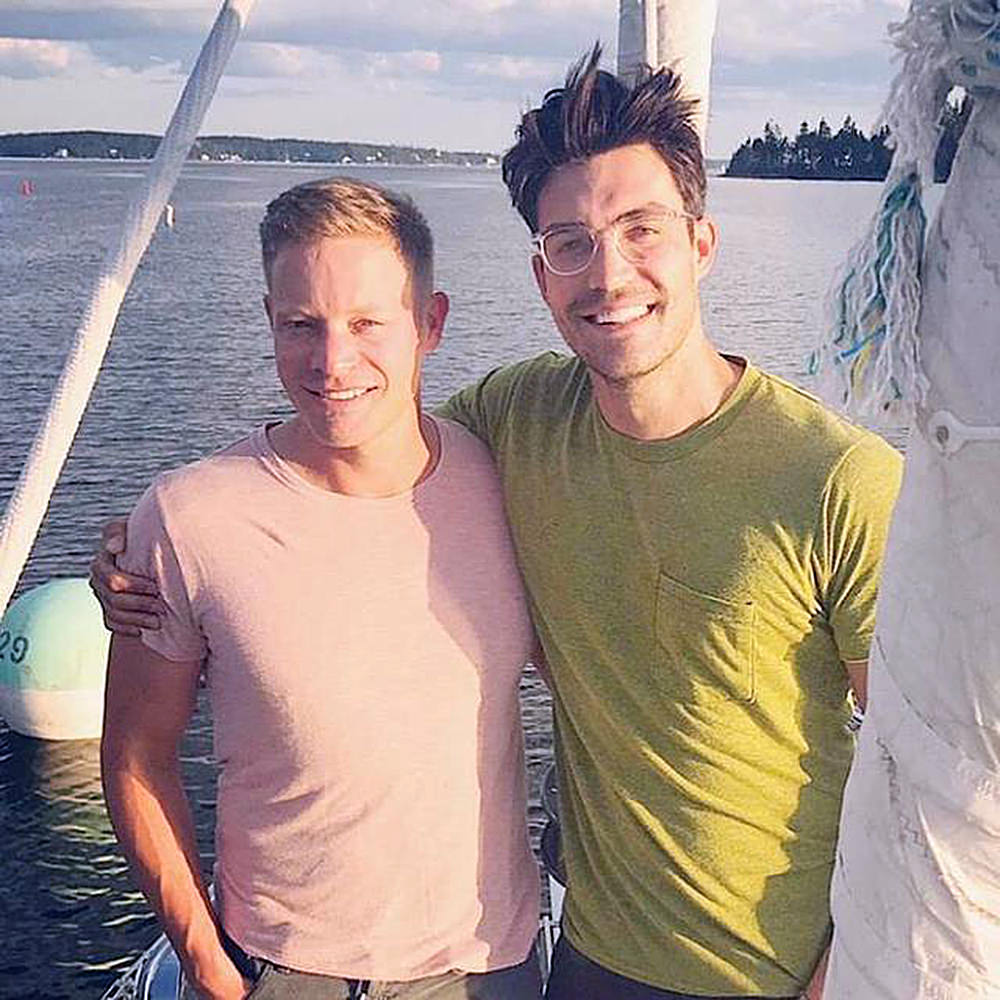 Peter Porte and his husband on a boat... you can see water in the background.