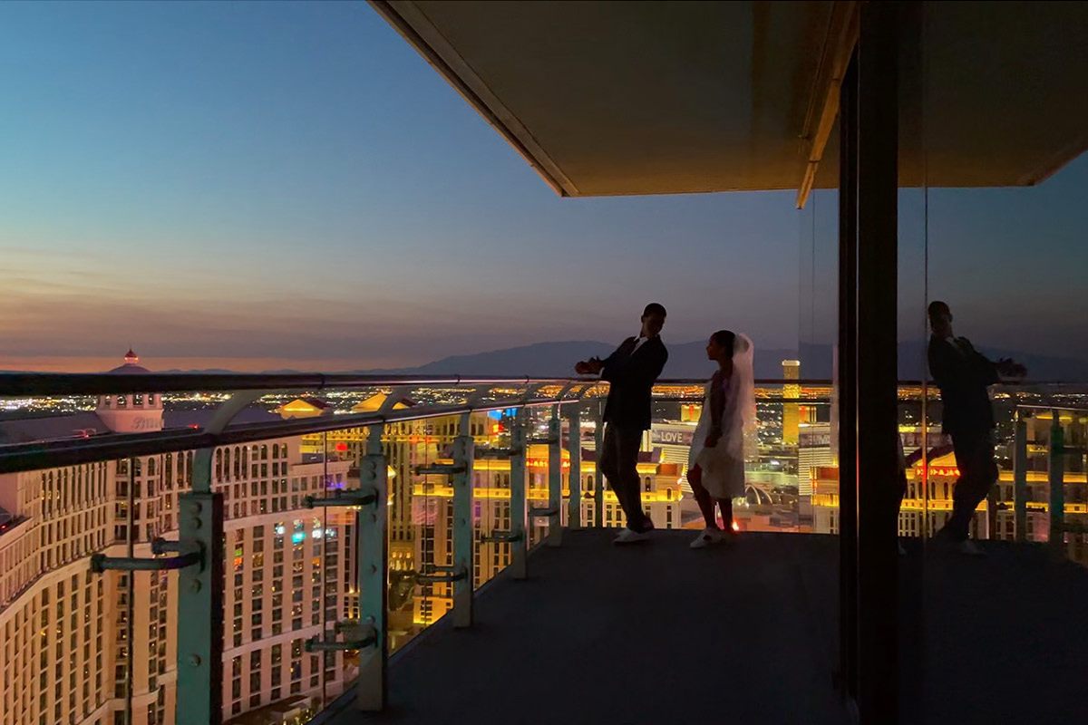 Video still of two people on a balcony overlooking Vegas.