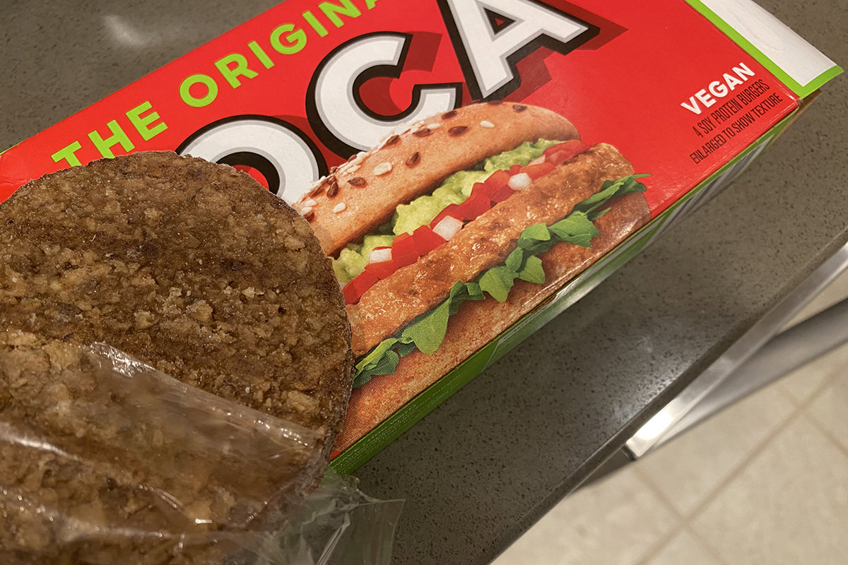 Dark brown actual burger next to the light colored patty on the box.