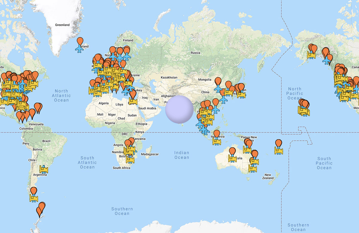 A world map with a hole in the middle and various flags showing places I've traveled.