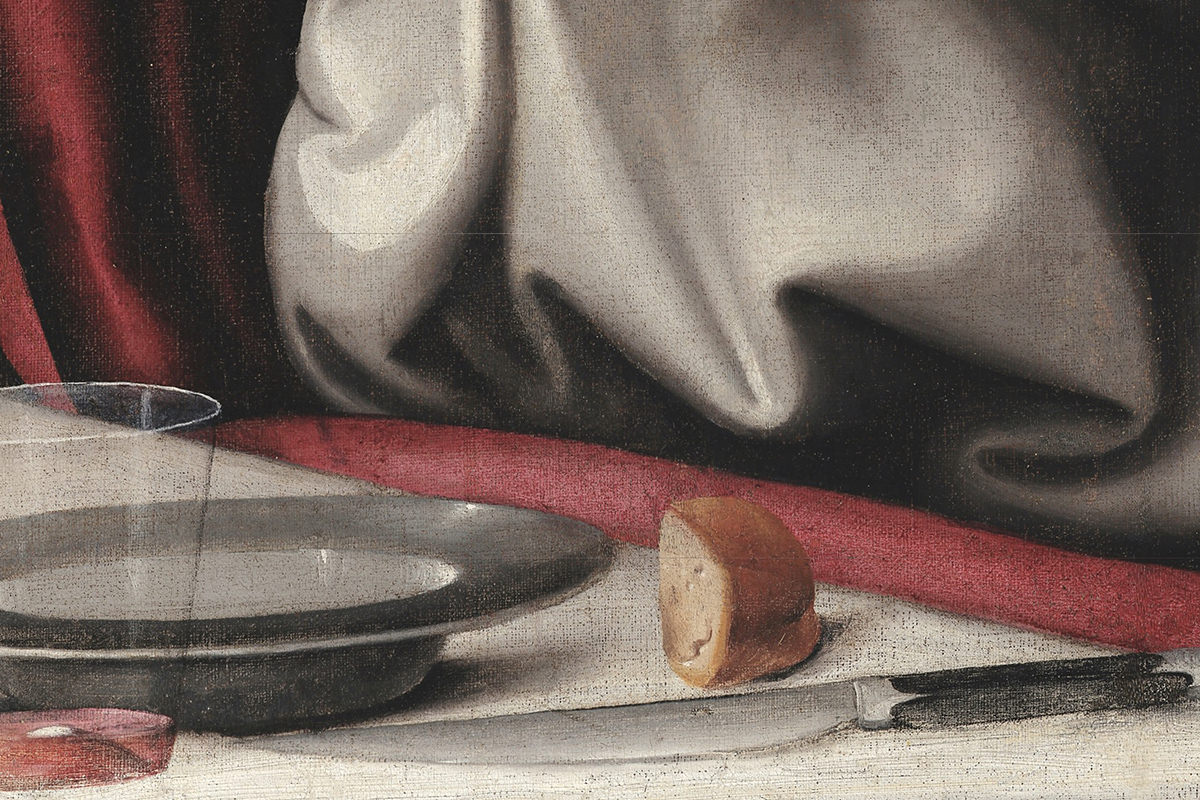 A slice of bread sitting on the table in close-up zoom-in on The Last Supper