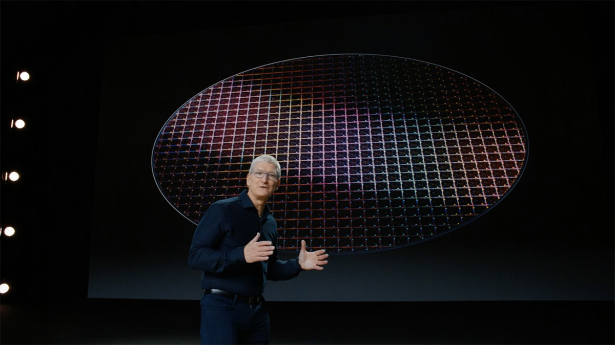 Tim Cook standing in front of computer chips on a big wafer.