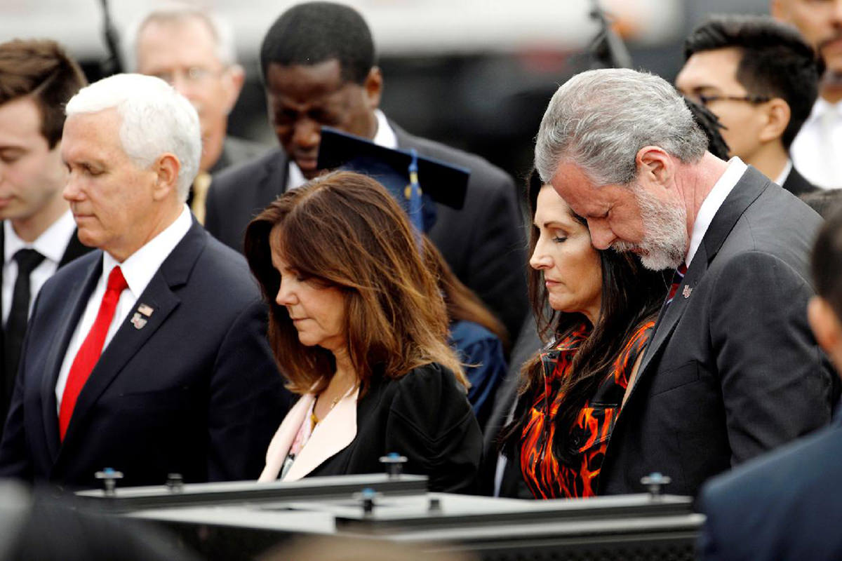 Vice President Pence and Jerry Falwell Jr. with their wives, their heads bowed in prayer looking like the assholes they are.