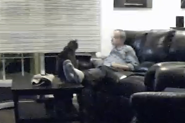 Me talking to my cat Jake in a low-res security camera still photo.