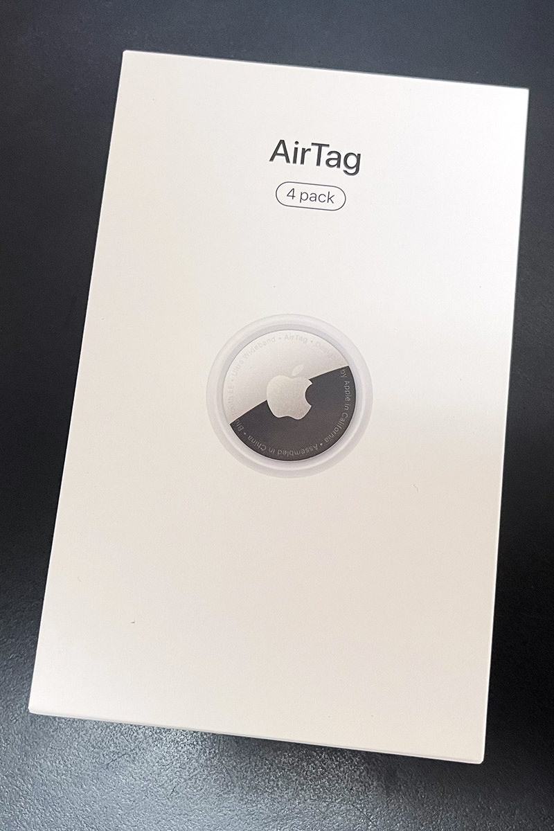 Apple's AirTag packaging, which is just plain white with a picture of an AirTag puck and the word AirTag on it.