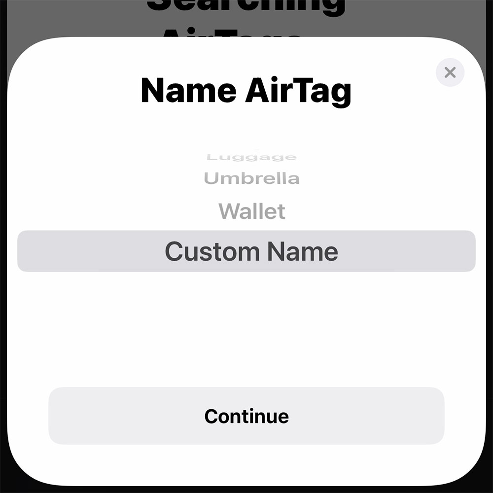 An opened Apple AirTags box with the four AirTags seated in an instruction card.