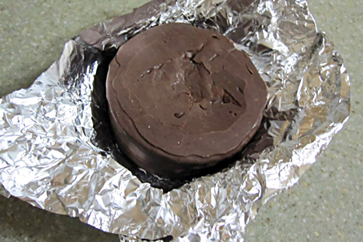 A Hostess Ding Dong snack cake sitting in a foil wrapper.