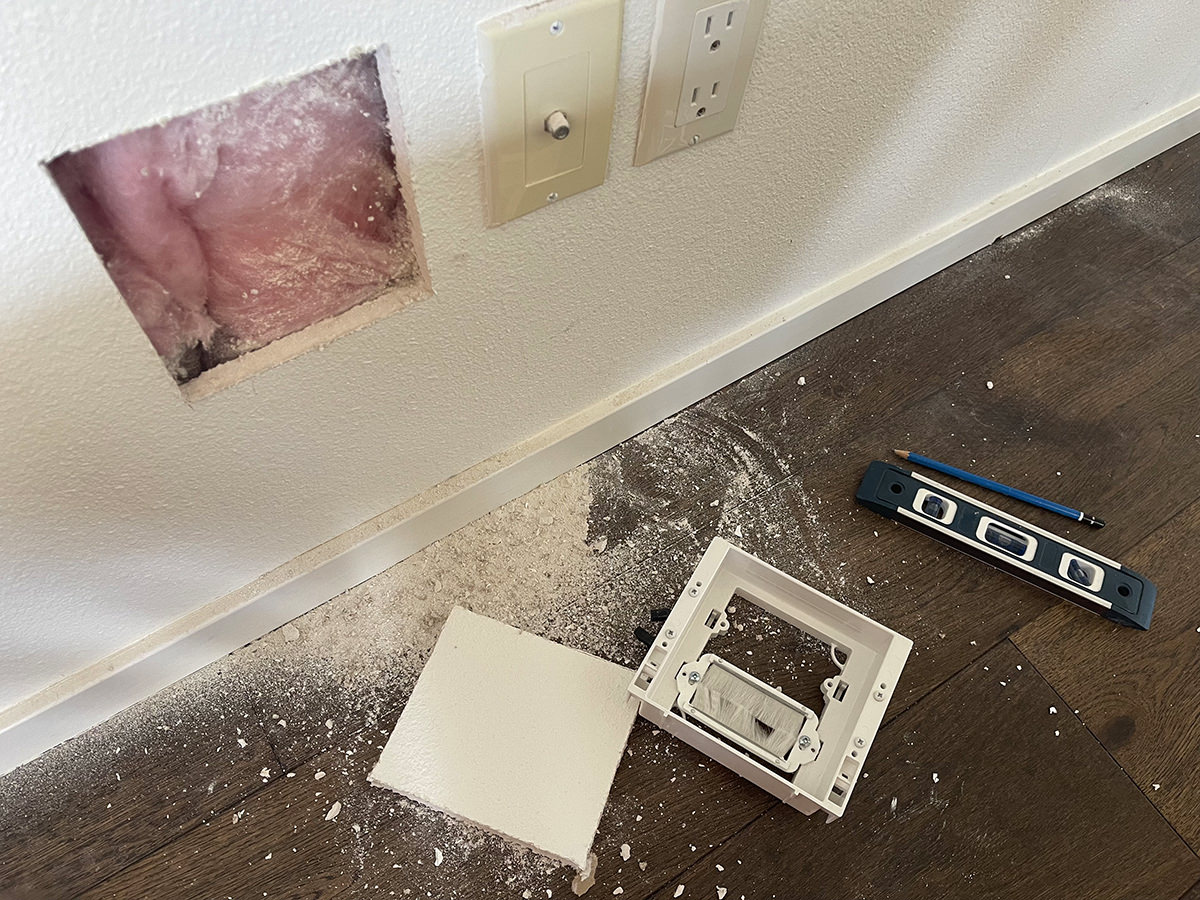 A hole being cut in my drywall for the cable box.