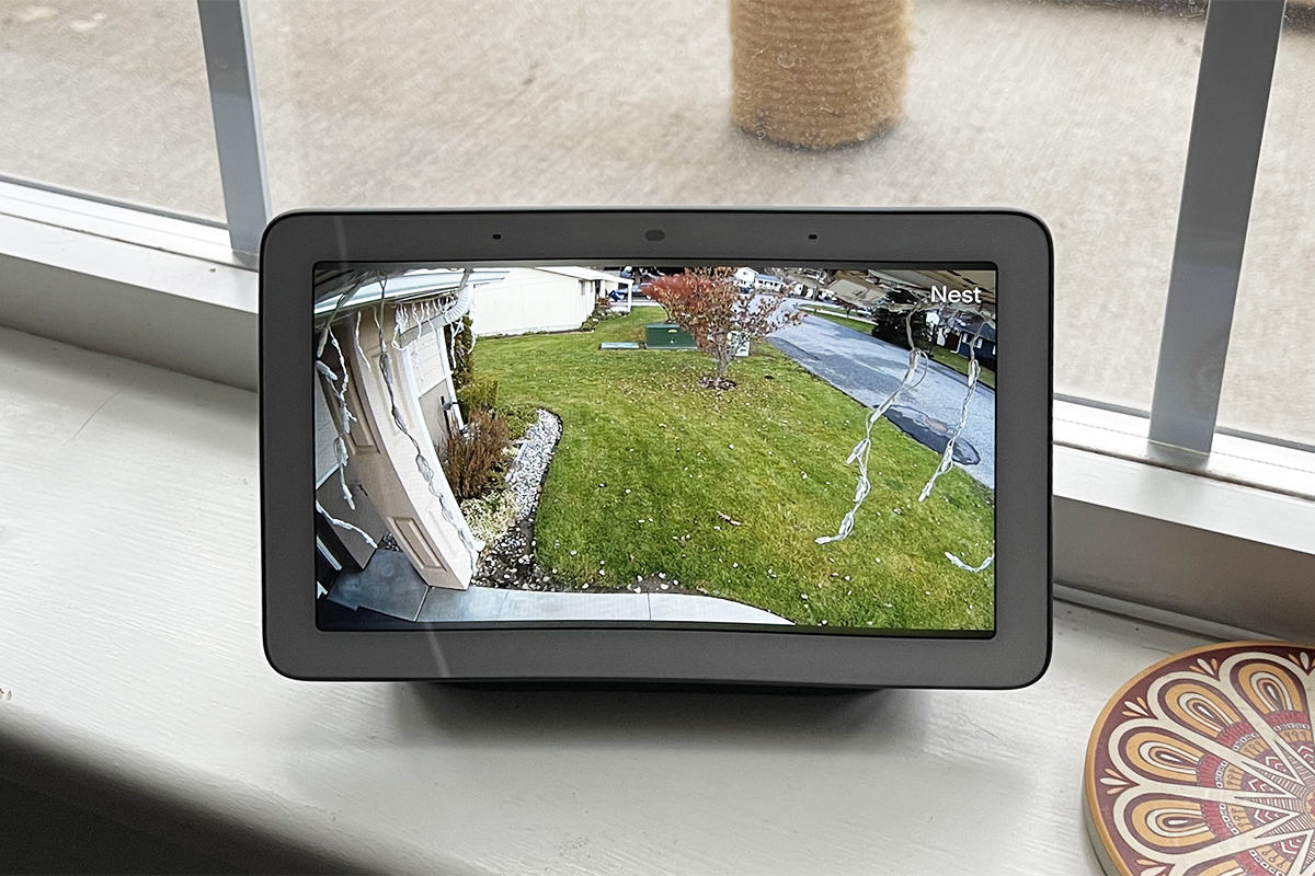 The Google Nest Hub Frame showing my front yard on it's screen... which is sitting in my living room window frame.