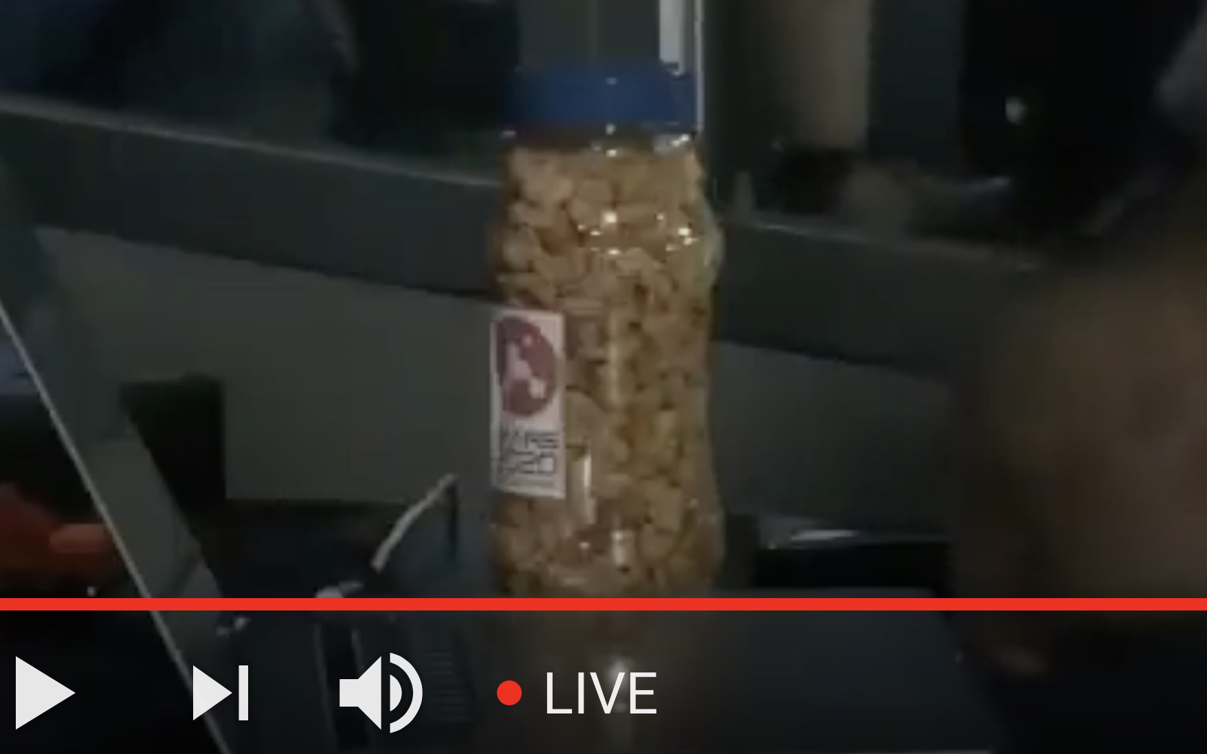 Closeup of what looks like a jar of peanuts sitting next to the NASA engineer.