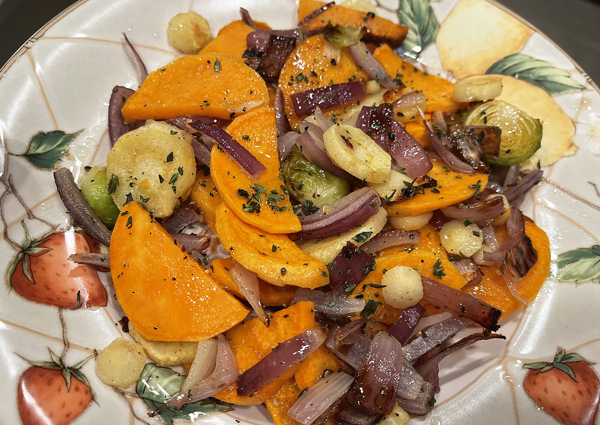 A plate with roasted sweet potatoes, turnips, brussel sprouts, and onions.