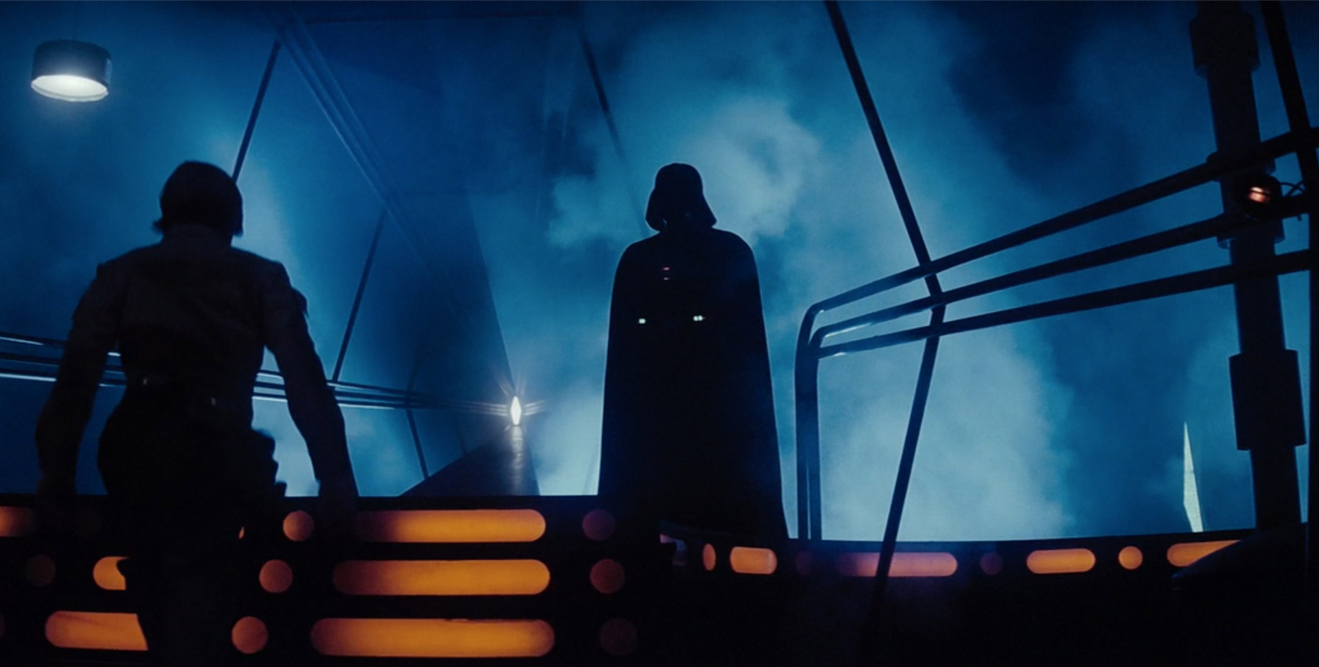 Darth Vader stands menacingly in the shadows while luke approaches to battle!