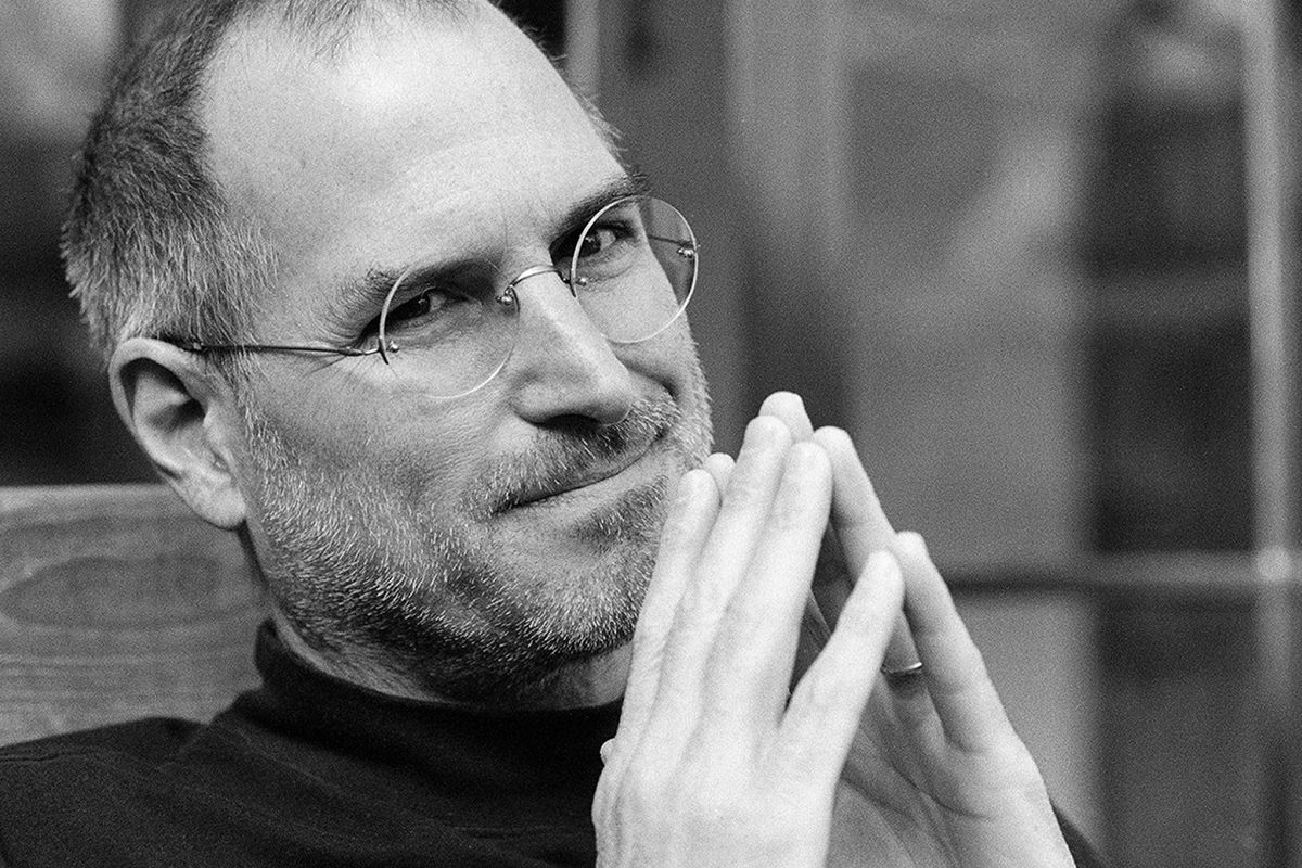 Steve Jobs smiling and looking like a genius.