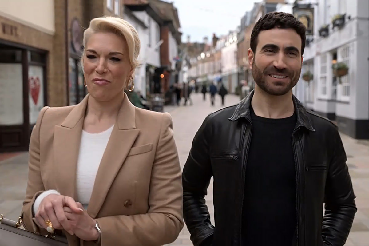 Rebecca and Roy walking down a street together.