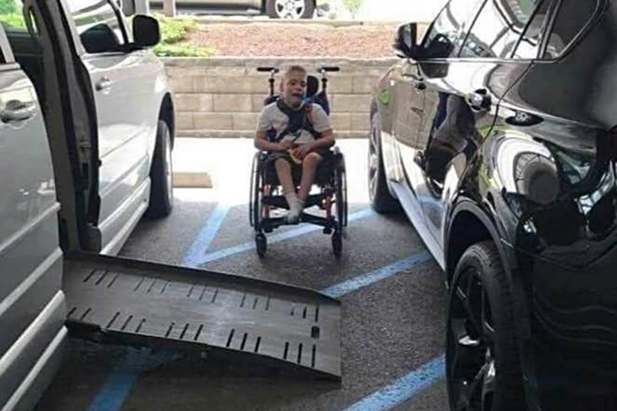 Somebody parked in an unloading area, so a young child in a wheelchair can't get up the ramp into a van.